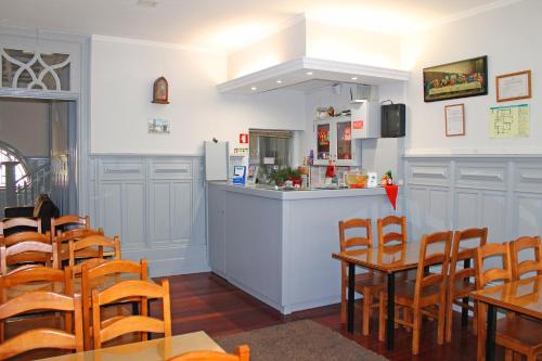 a restaurant with a counter and tables and chairs at Hotel Porto Nobre in Porto