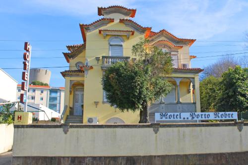 a yellow house on top of a wall at Hotel Porto Nobre in Porto