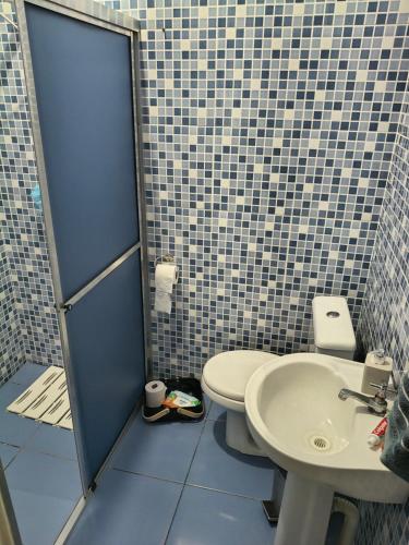 a bathroom with a toilet and a sink at Recanto Vila Madalena in Caçapava