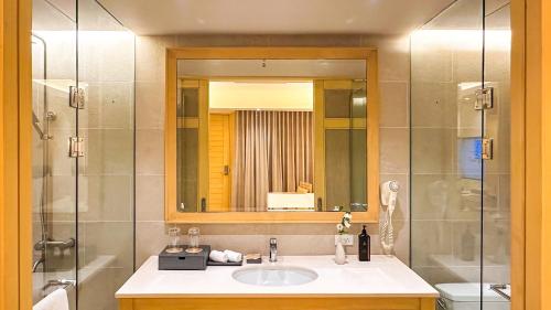 a bathroom with a sink and a shower with a mirror at Mandarin White Sand Boracay in Boracay