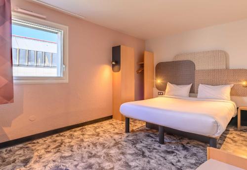 a hotel room with a bed in a room at B&B HOTEL Versailles Le Chesnay in Le Chesnay