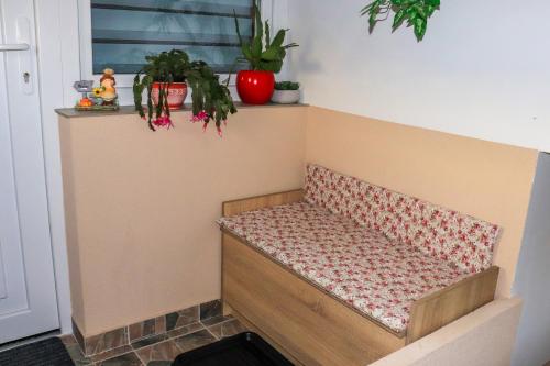 a bench in a room with plants and a window at Németh Apartman in Kisapáti