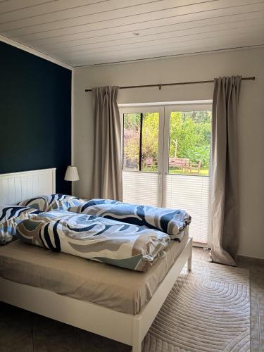 a bedroom with a bed and a large window at Alte Schule Rietz in Treuenbrietzen