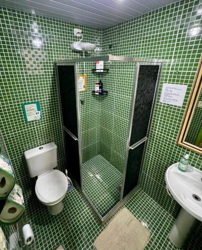 a green tiled bathroom with a toilet and a shower at Hostel New Ipanema in Rio de Janeiro