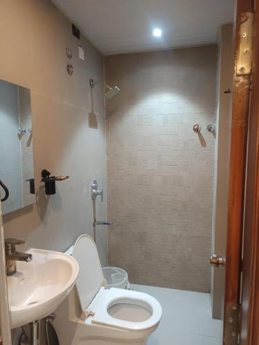 a bathroom with a toilet and a sink and a shower at Hotel Tals Hytek in Hyderabad