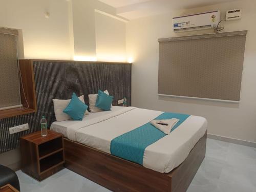 a bedroom with a large bed with blue pillows at Hotel Tals Hytek in Hyderabad
