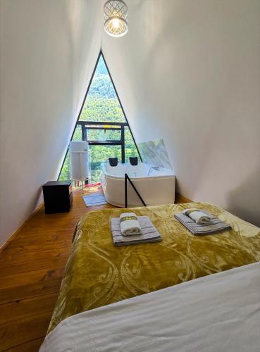 een slaapkamer met een bed en een groot raam bij Arditi's Chalets in Bogë