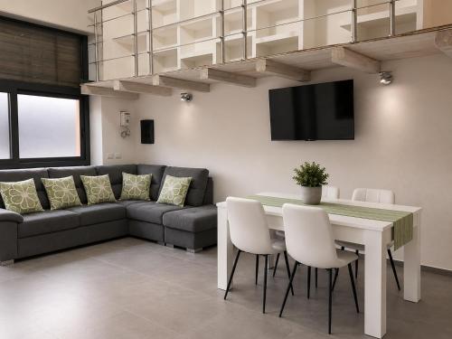 a living room with a table and a couch at Urban charme loft in Dorgali