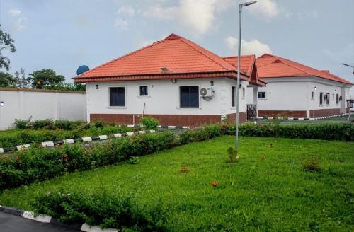 a white house with a red roof and a yard at Smile Apartment in Ilishan