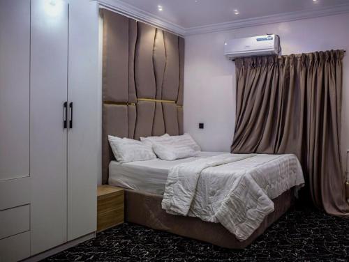 a bedroom with a bed with a window and a heater at Smile Apartment in Ilishan