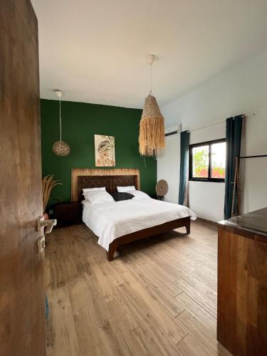a bedroom with a bed and a green wall at Shadamaltess in Azuretti