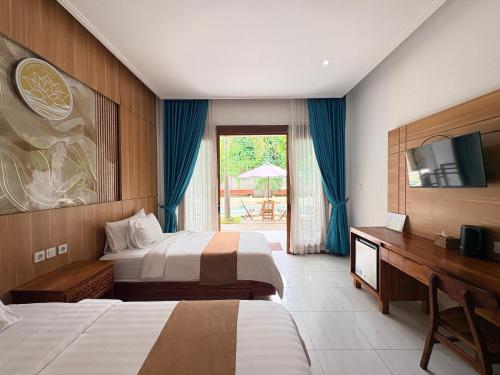 a hotel room with two beds and a desk at De Padma Gili Air in Gili Islands