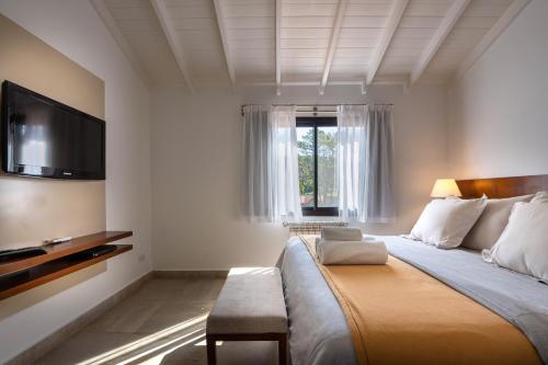 a bedroom with a large bed with a flat screen tv at Ville Saint Germain Apart Hotel & Spa in Carilo