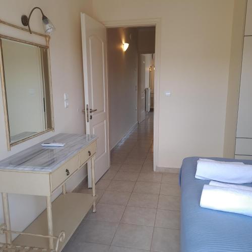 a bedroom with a sink and a mirror and a bed at Irini's Villa in Argostoli