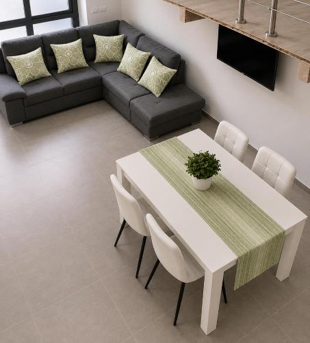 a living room with a white table and a couch at Urban charme loft in Dorgali