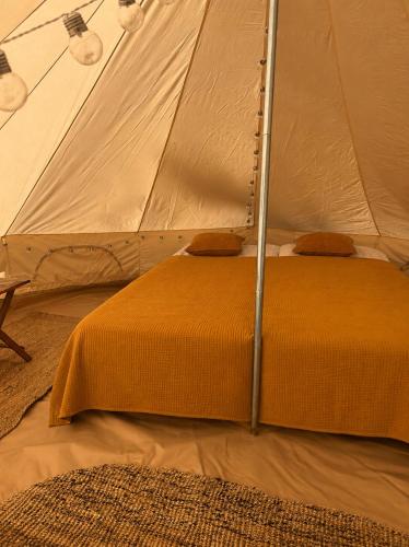 a bed in a tent in a room at Glamping teltta Venekoski in Hankasalmi