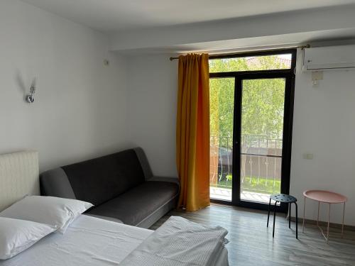 a bedroom with a couch and a large window at Tropical Beach in Eforie Sud