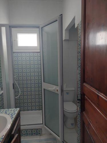 a bathroom with a shower and a toilet and a sink at Résidence Kyranis appartement Noix de Coco in Sfax
