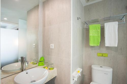 a white bathroom with a sink and a toilet at MaxOneHotels at Ubud - CHSE Certified in Ubud