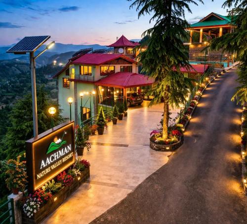 a hotel with a sign on the side of a road at Aachman Nature Valley Resort MASHOBRA in Shimla