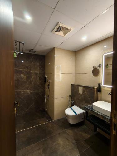 a bathroom with a toilet and a shower and a sink at Hosta Inn Hotel and Resort in Edappāl