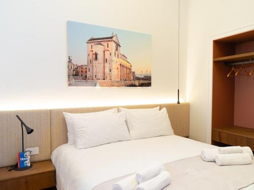 a bedroom with a large white bed with towels on it at Cala Bianca in Trani