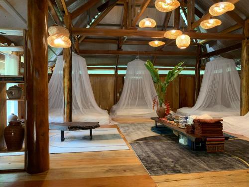 a room with four beds with mosquito nets at Homestay Hùng Phát Pù Luông in Làng Chiêu