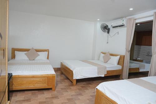 a hotel room with two beds and a window at CATBA PANDORA Hotel & Travel in Cat Ba
