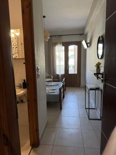 a hallway with a kitchen and a room with a table at Roula's Apartment in Limenaria
