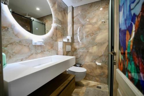 a bathroom with a sink and a toilet at Manolo & Jolie Luxury Villa in Himare