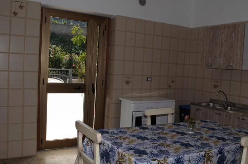 a room with a table and a kitchen with a window at B&B Sulla Spiaggia in Belmonte Calabro