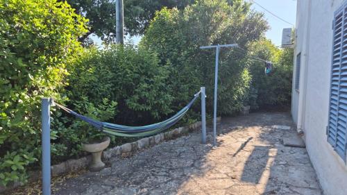a hammock in a garden next to a building at La Lamia celeste in Impalata