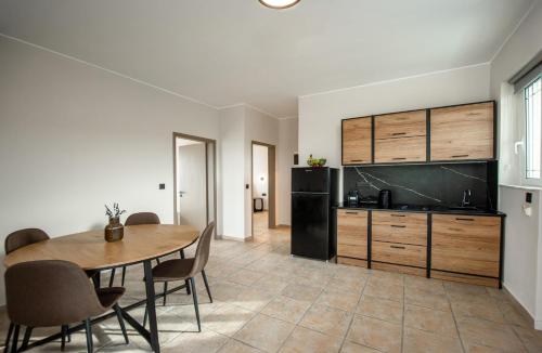 a dining room with a table and a kitchen at Sokrates Studios in Afantou