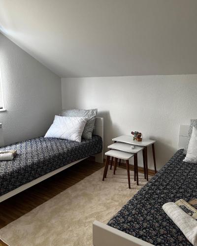 a room with two beds and a table in it at Villa Mercurii in Sarajevo