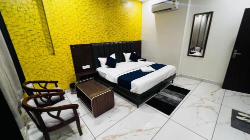 a bedroom with a bed with a yellow wall at Hotel AJL in Rohtak