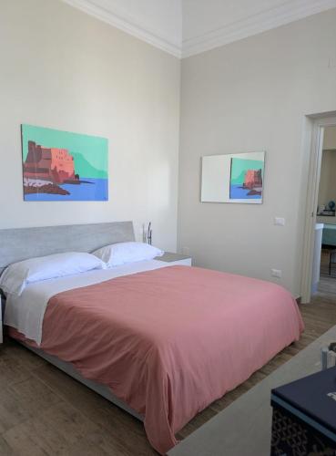 a bedroom with a large bed with a pink bedspread at Villa Carbonilla in Torre del Greco