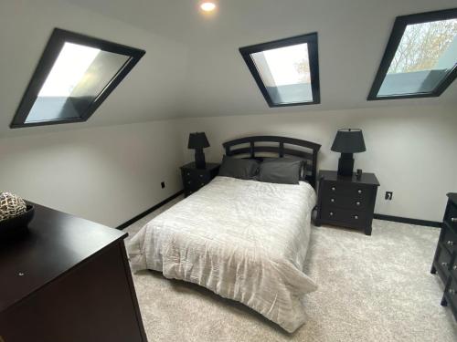 a bedroom with a bed and four windows at The Station House in Brantford