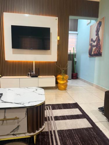 a living room with a large tv on a wall at Ivory Max in Ikeja