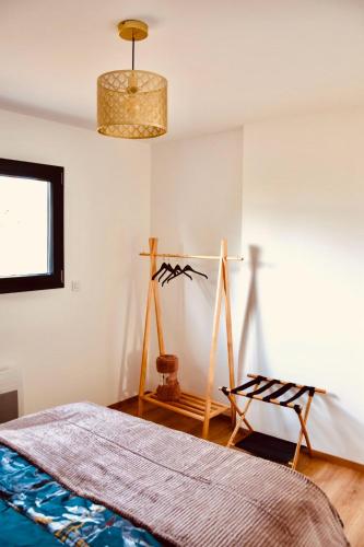 a bedroom with a bed and a chandelier at L'échappée Bourguignonne in La Vineuse