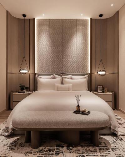a bedroom with a large white bed and a table at FairMounts Plaza Inns Near Delhi International Airport in New Delhi