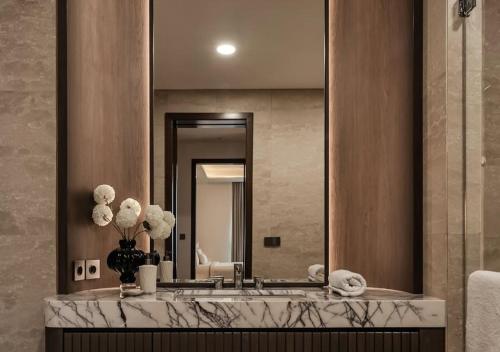 a bathroom with a sink and a large mirror at FairMounts Plaza Inns Near Delhi International Airport in New Delhi