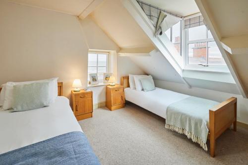 two beds in a room with two windows at Sandy Toes in Sandsend