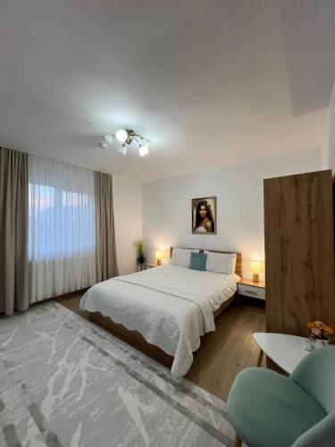 a white bedroom with a bed and a window at Casa Bocan in Geoagiu Băi