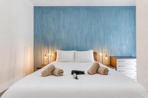 a bedroom with a white bed with a blue wall at Spacious and refined 3 bedroom duplex KARP1-1 in San Ġwann