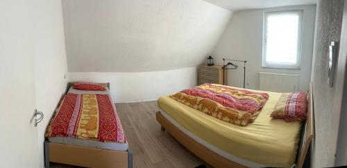 a small bedroom with two beds and a window at Ferienwohnung Sauerländer in Plettenberg