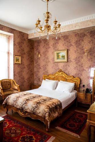a bedroom with a large bed and a chandelier at The Moonlight Luxury Hotel in Baku