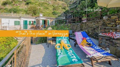 a balcony with two lounge chairs and a house at Camere Giuliano basso in Vernazza