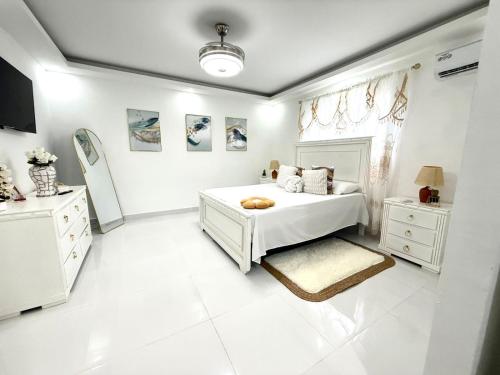 a white bedroom with a bed and a window at Cange in Albana