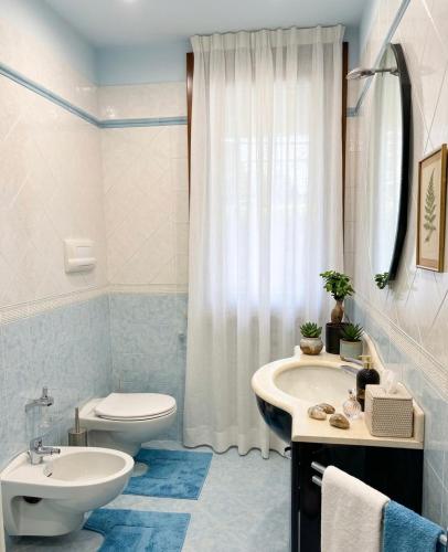 a white bathroom with a toilet and a sink at Azzurro Garda in Sirmione