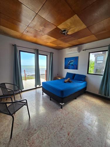 a bedroom with a blue bed with a view of the ocean at Hotel Horizonte Azul in Casares